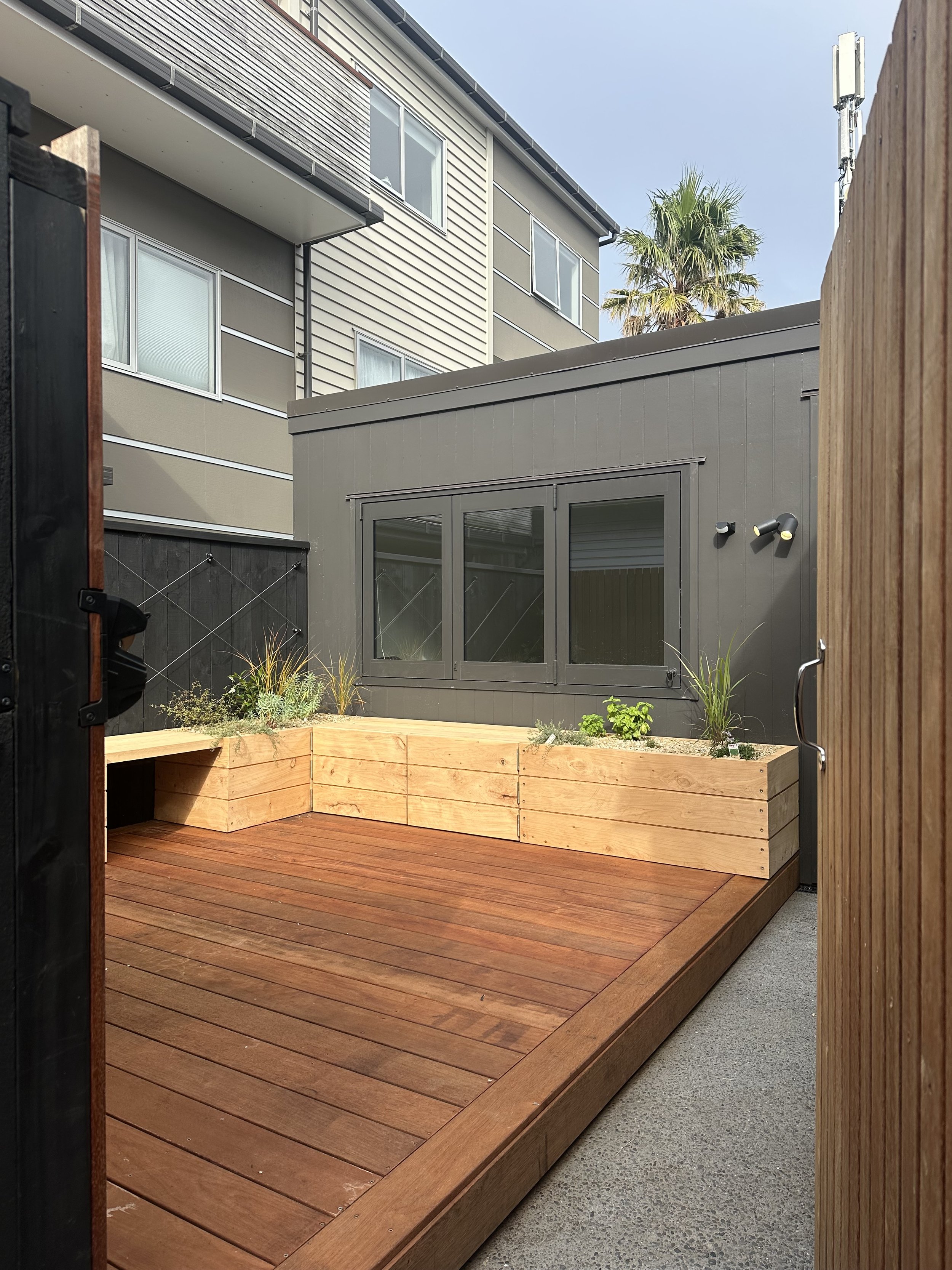 Spacious hardwood deck with stairs leading to a garden