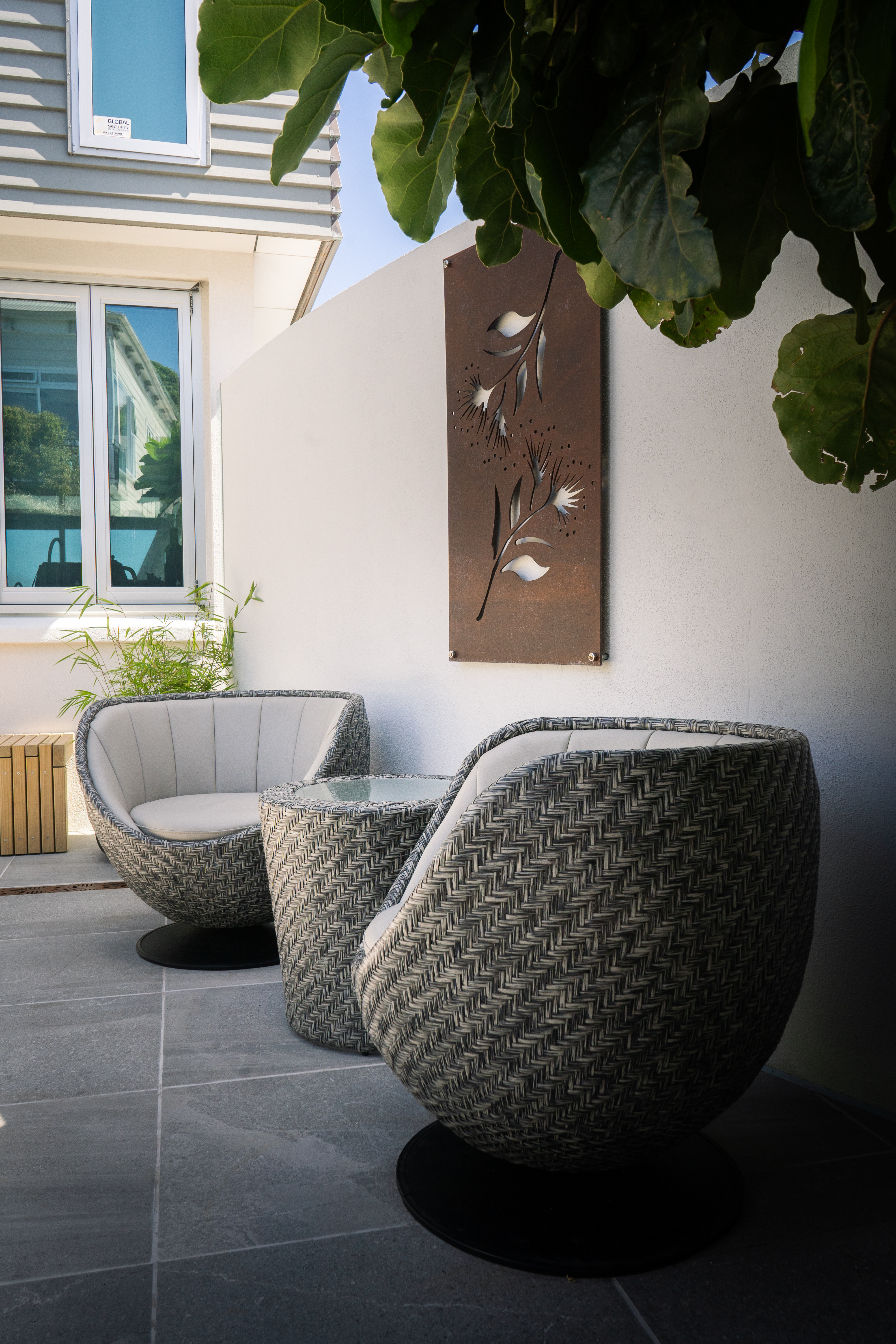 Lush green foliage against a modern fence.